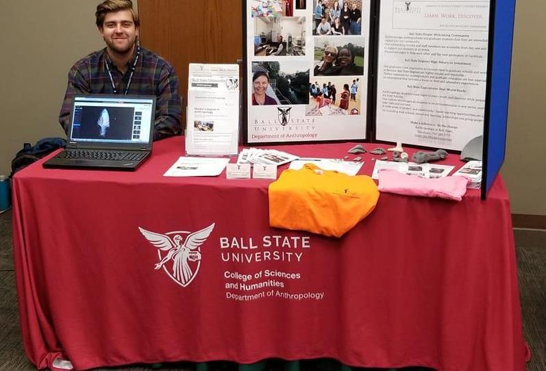 Graduate student, Connor McCoy mans the information table