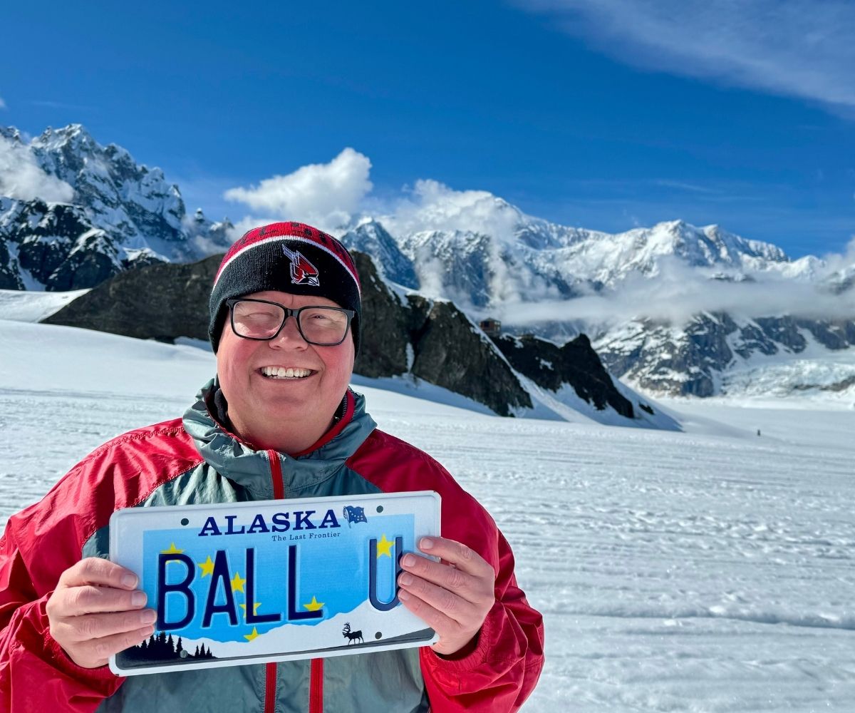 Alaska Club member in front of mountains