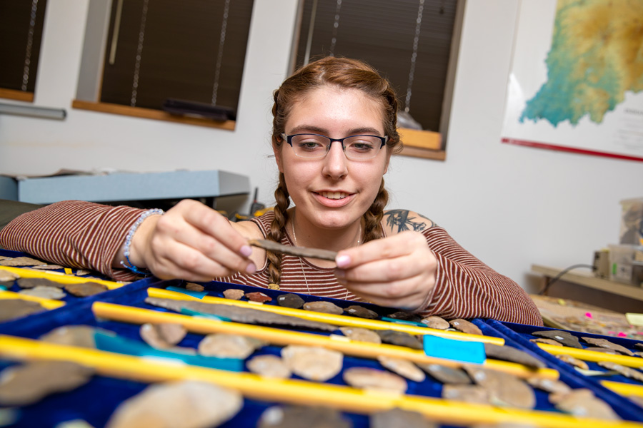 student examining an artifact