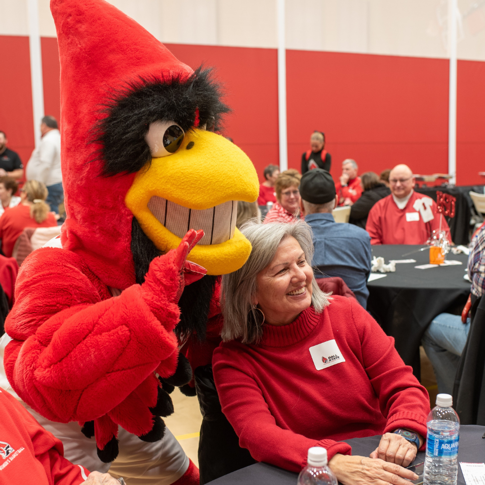 Charlie Cardinal chirping with person in a red top at VIP reception