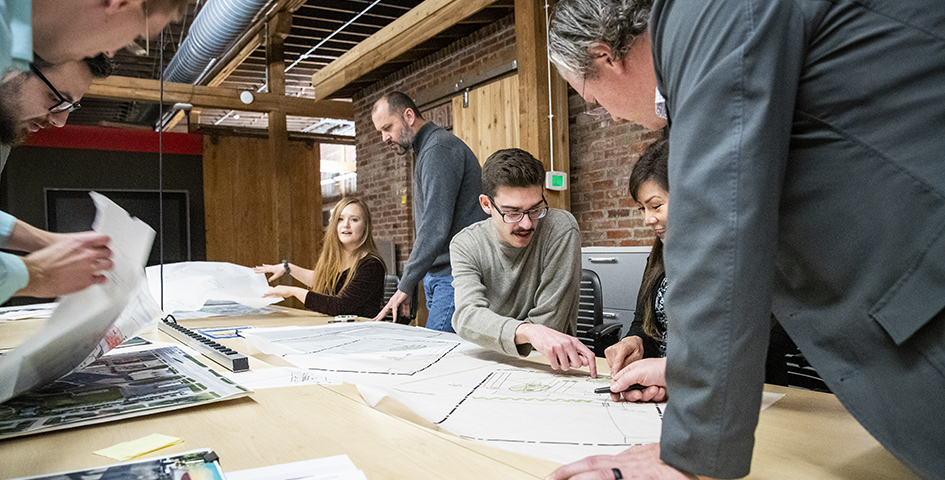 Master of Urban Design students with Professor Blalock discussing a project.