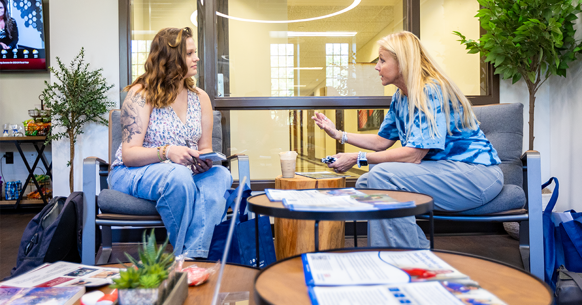 A girl ball state student sits with a advisor talking 