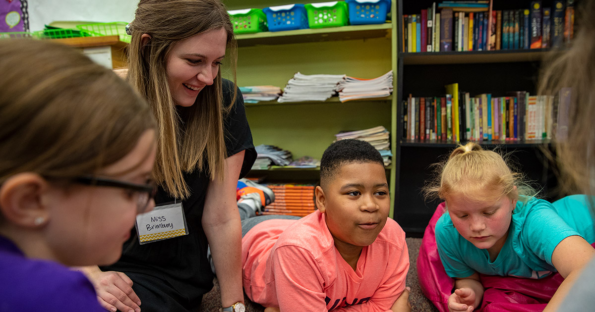 A teacher instructs her students in a classroom setting