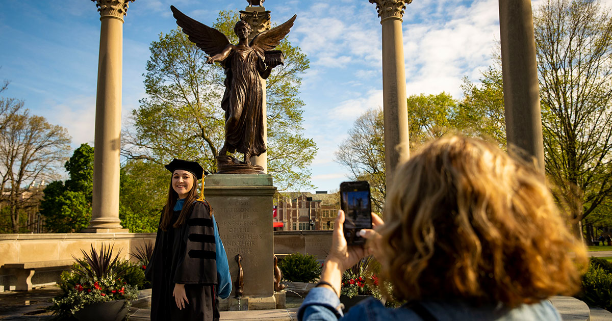 Graduate taking pictures in front of Benny - Ball State University Spring 2022 Commencement