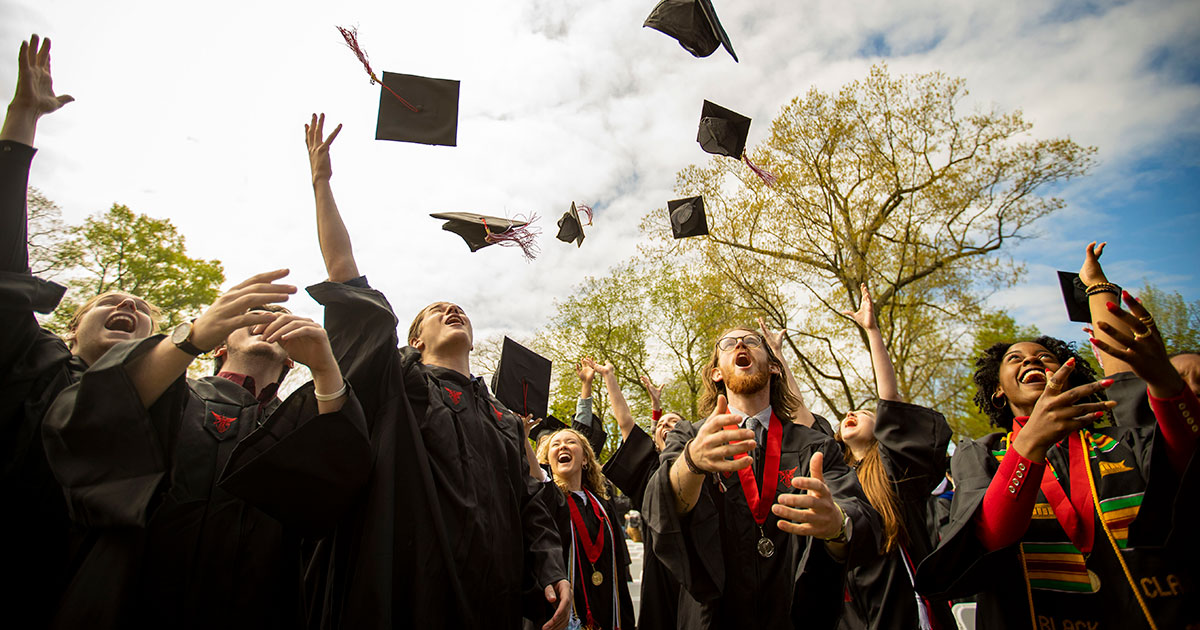 Graduates throwing their caps into the air - Ball State University Spring 2022 Commencement