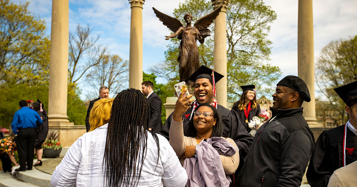 Graduate taking pictures in front of Benny - Ball State University Spring 2022 Commencement