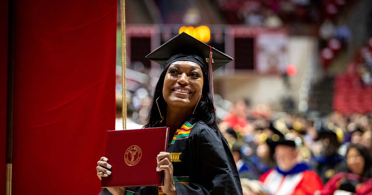 Student poses with diploma