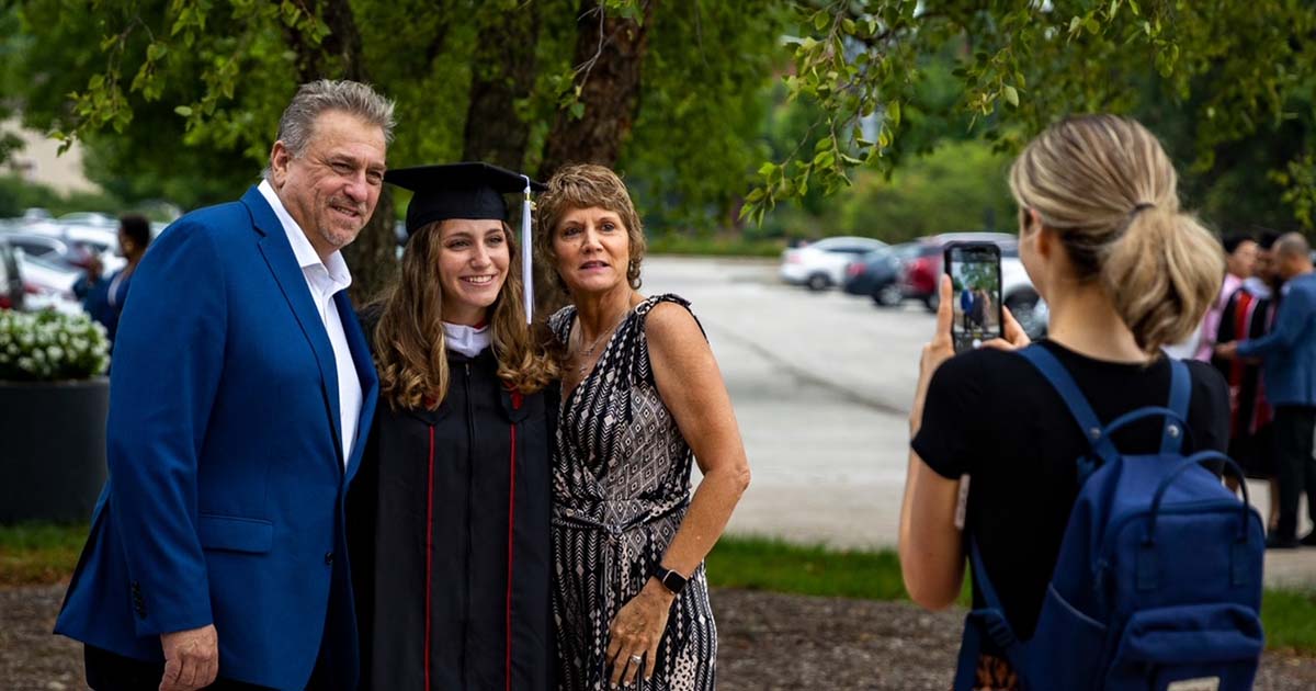 student posing with parents