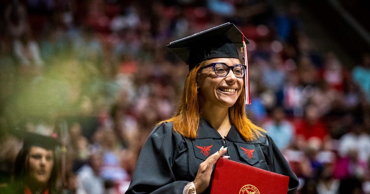 Graduate posing with diploma