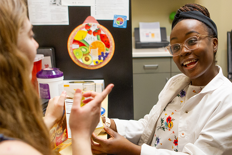 A Ball State student counsels a patient about healthy food choices