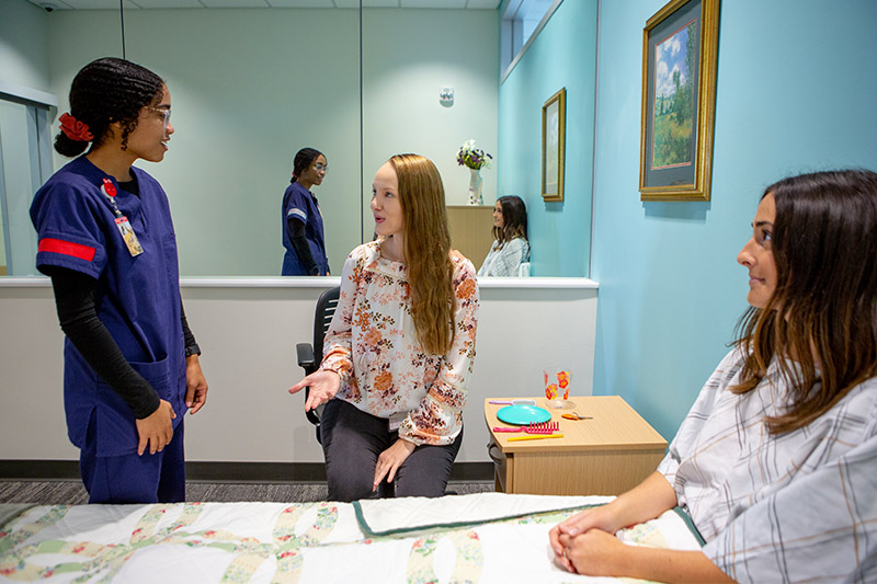 Students work together in helping a patient
