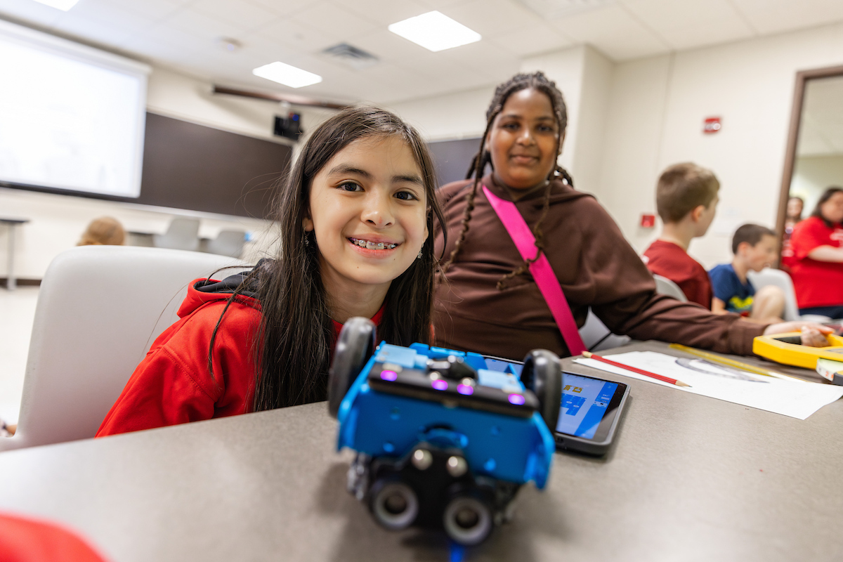 Students at a desk with robot