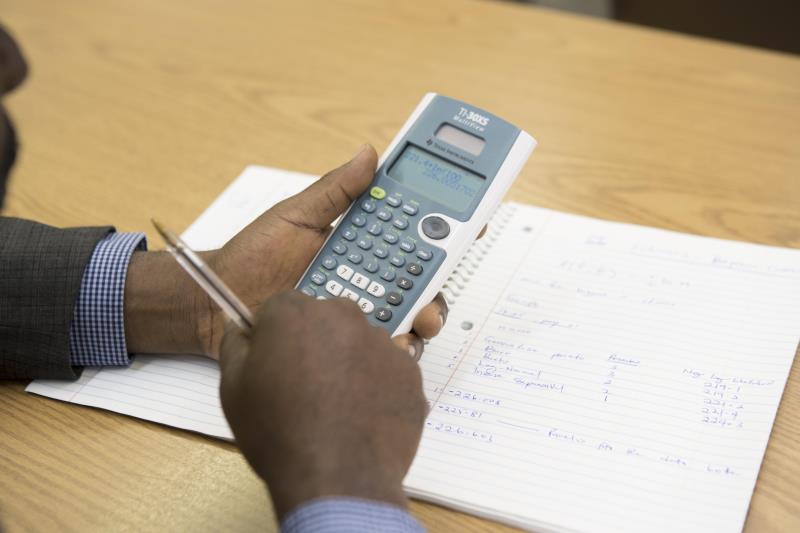 Economics student holding a calculator. 