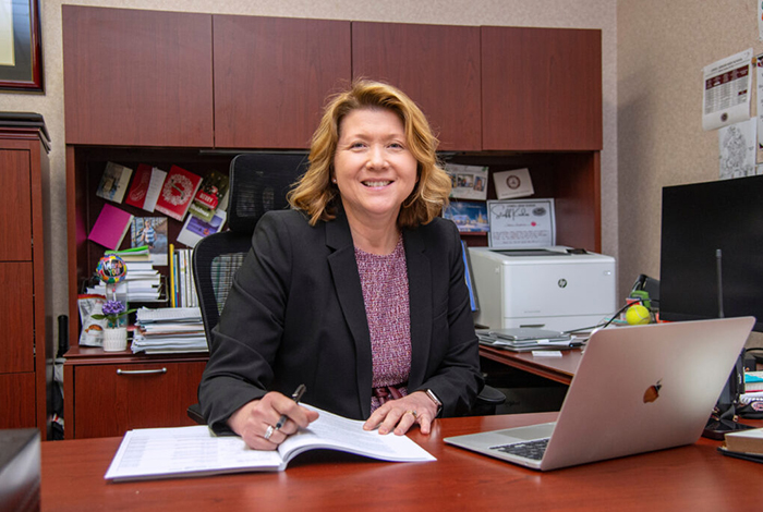 Educational Leadership graduate sitting at her desk