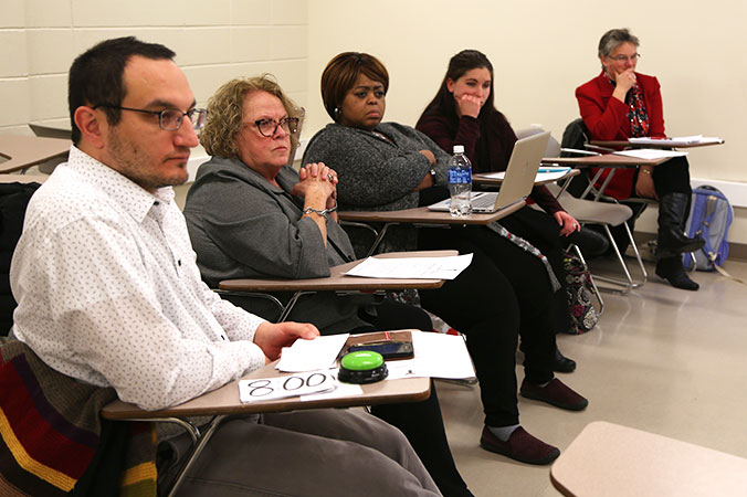 A group of adults sitting in a classroom.