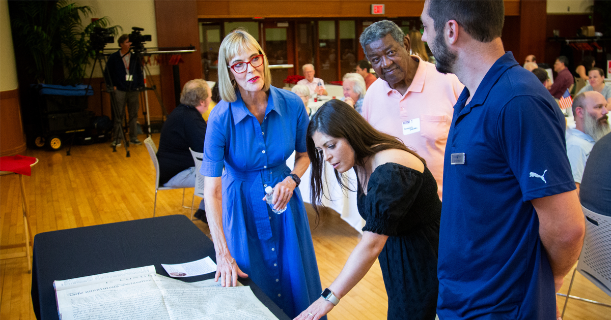 Some attendees of the civic learning symposium looking at a very important legal document preserved over the ages