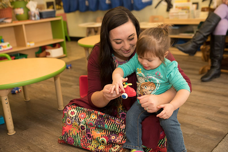 A student working with a young child.