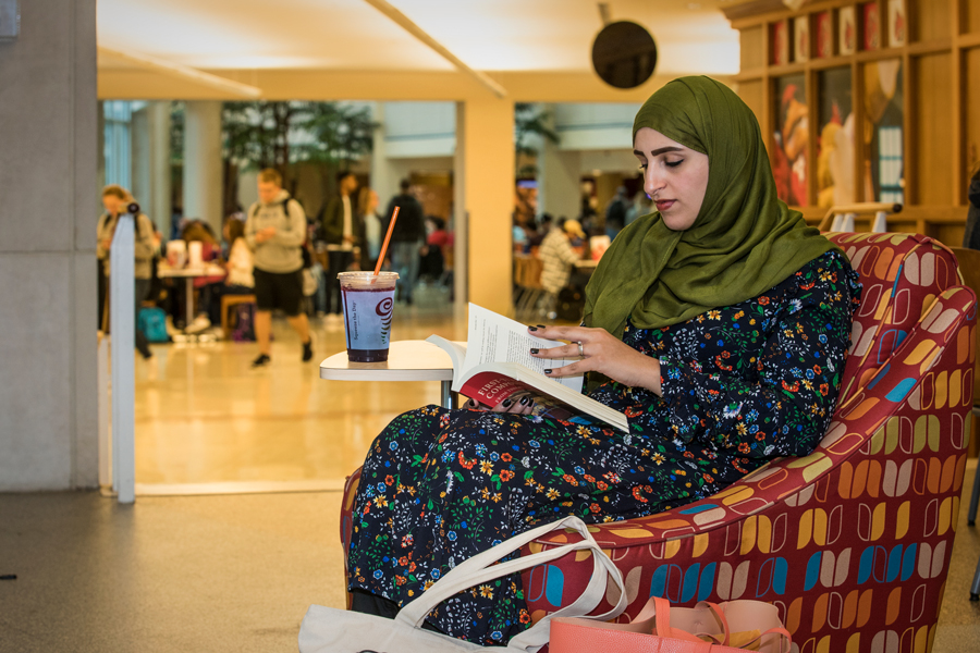 international student reading in the Atrium