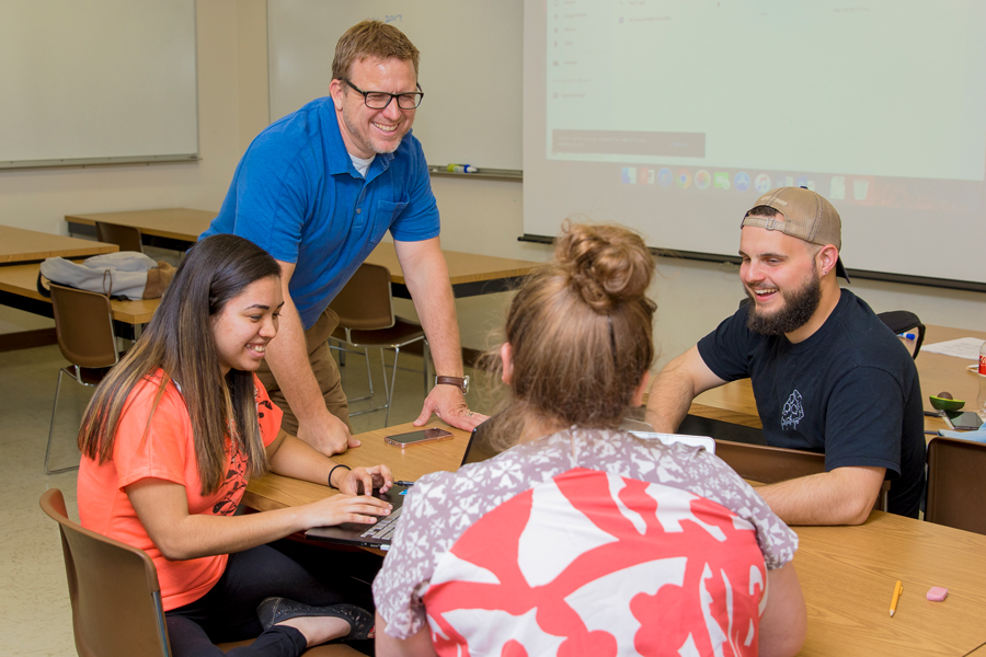 Man with college students smiling