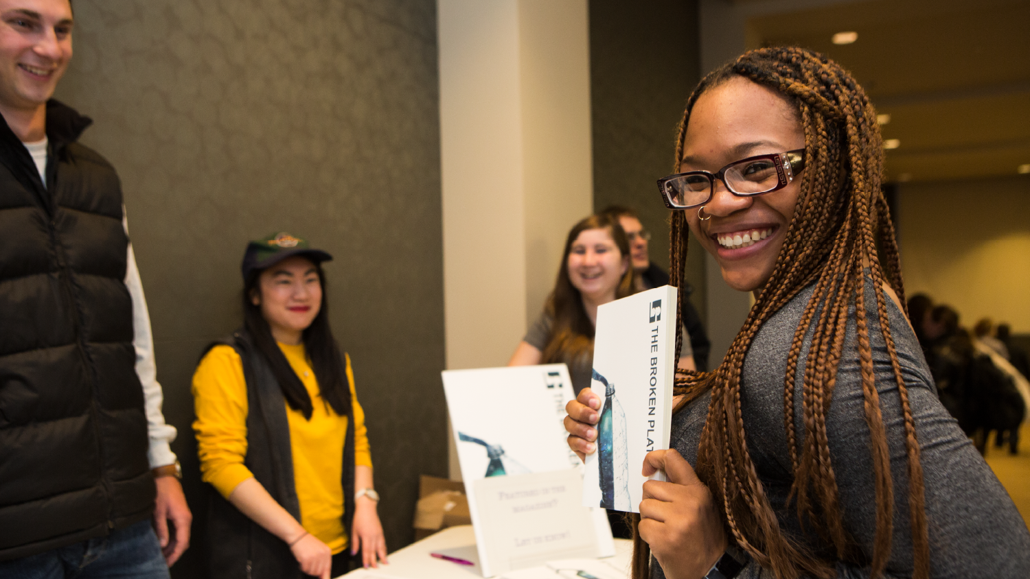 Student shows a book at a conference table.