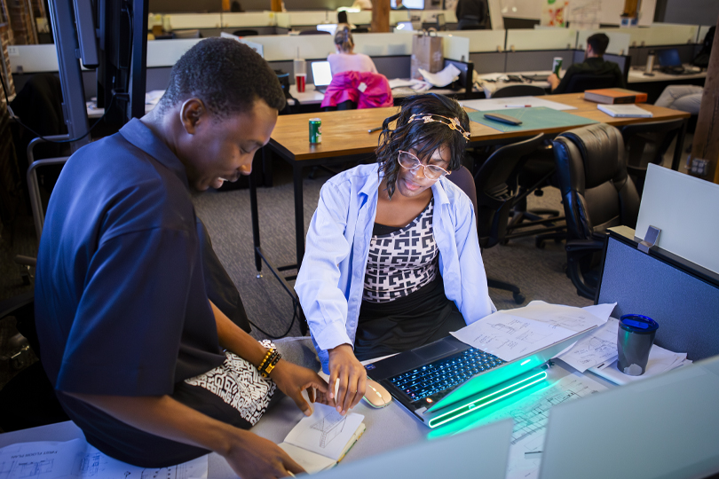 Students sitting at desk looking at project