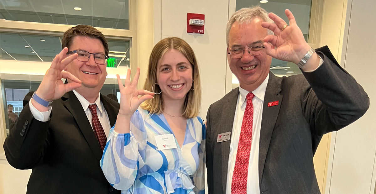 Chiara Biddle, Alumna of Ball State Honors College, Dean Jim Buss and his predecessor Dean John Emert posing for photos throwing up Ball State's Beloved "Chirp Chirp"