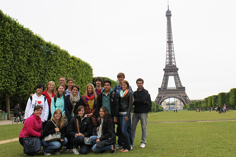 group of study abroad students pose for photo in front of Eiffel Tower