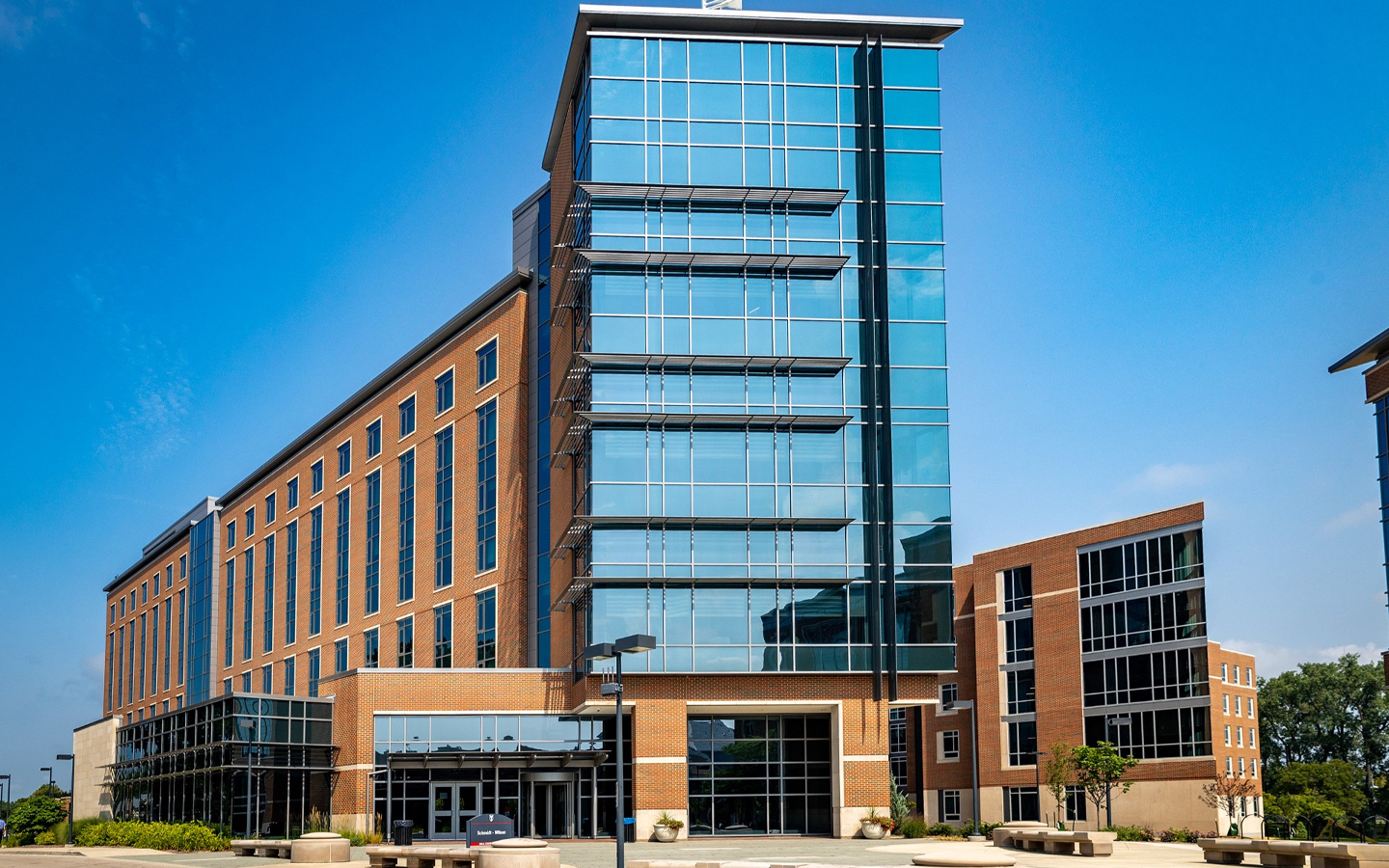 tall residence hall building with glass windows and a blue sky