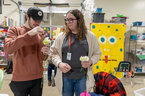 Two students hold flowers at Beyond i Can