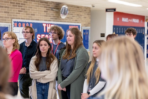 A group of student stand in a school hall