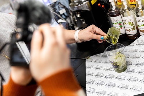 A student videos a person making a coffee drink