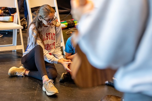 A student helps a younger student