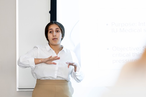 A student presents in front of a screen