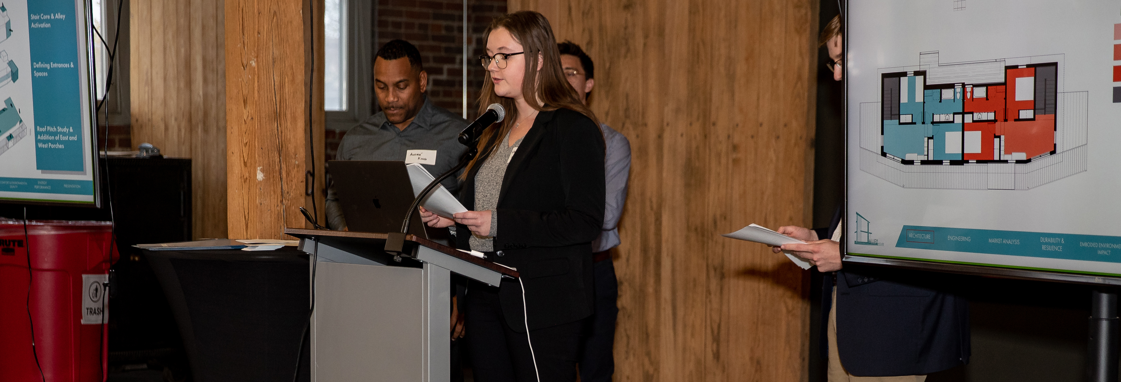 Four students standing in front of a podium