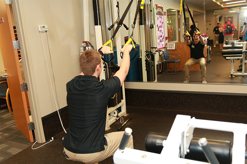Student works on exercise machine.