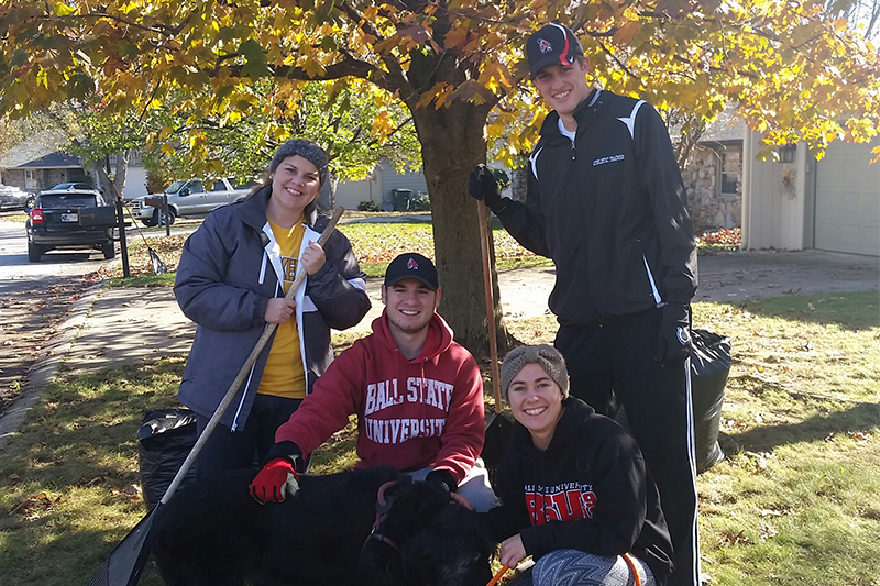 Physical Education Student Association members rake leaves.