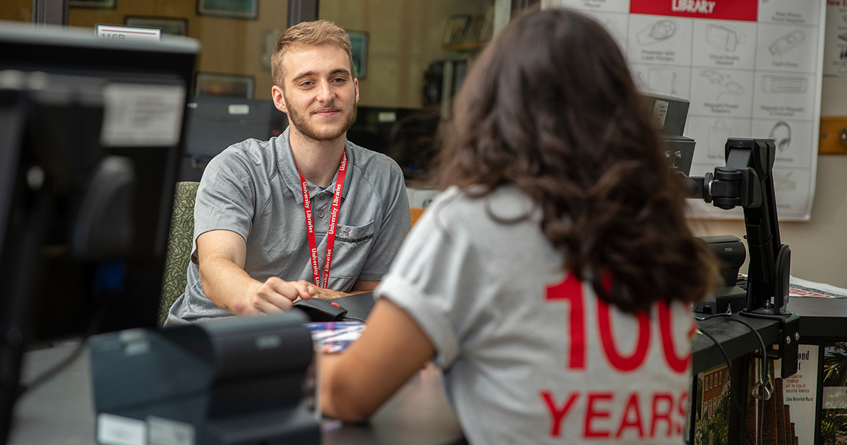 A student checks out an item at the Library