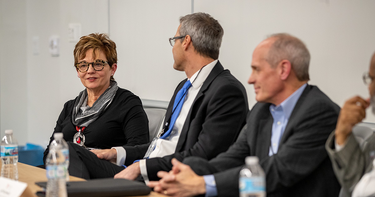 Four alumni panelists dressed in professional clothing sit at a conference table during Dialogue Days at Ball State University’s Miller College of Business.