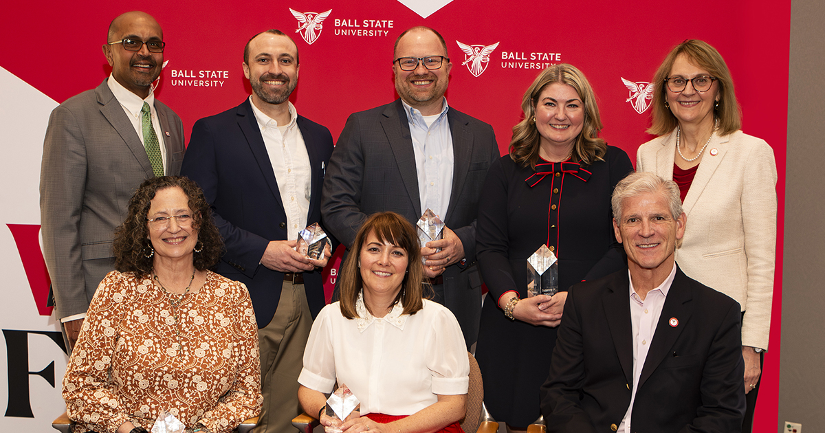 Group photo of the 2026 Miller College Alumni Award recipients holding their awards and standing in front of a banner with the ball state logo and #wefly