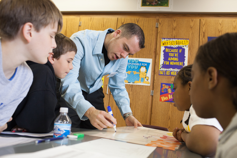 teacher working with elementary students