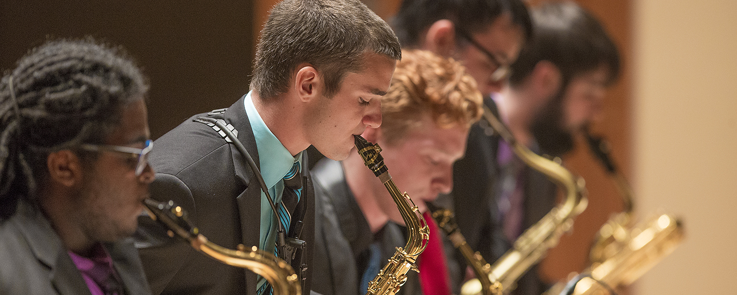 students performing saxophone on stage