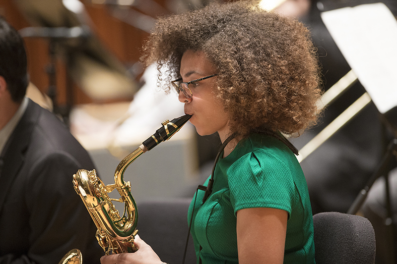 female saxophone player practices on stage