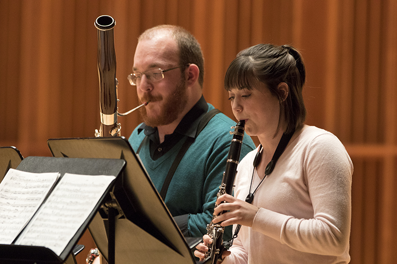 students perform on stage playing the bassoon and oboe