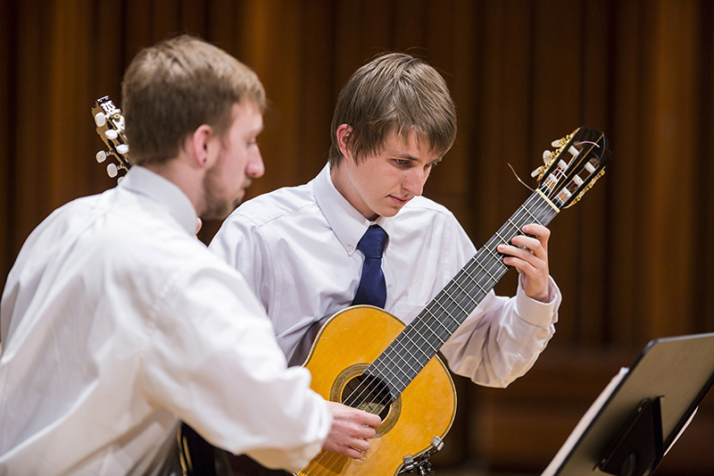 students perform on stage in the guitar ensemble