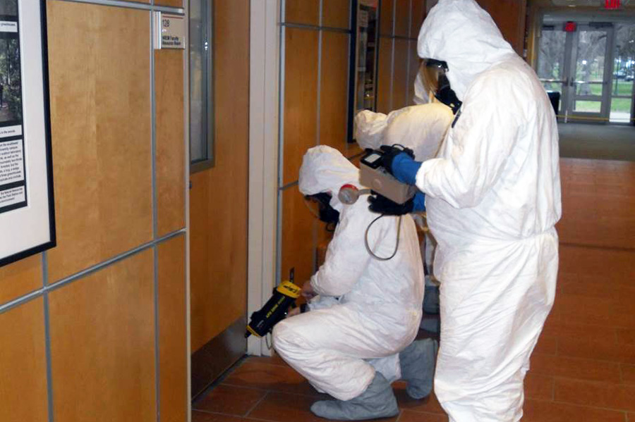 people wearing hazmat suits conduct an inspection