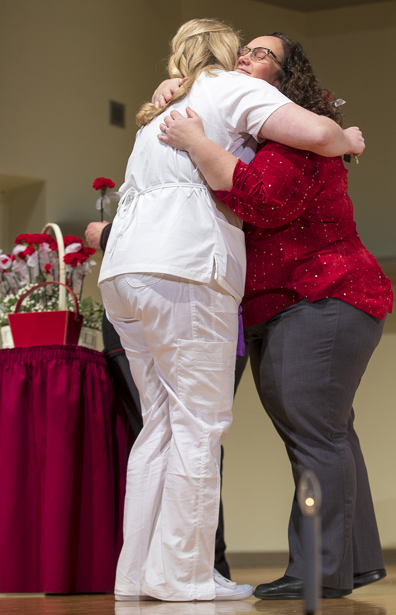 student and instructor hugging during pinning ceremony