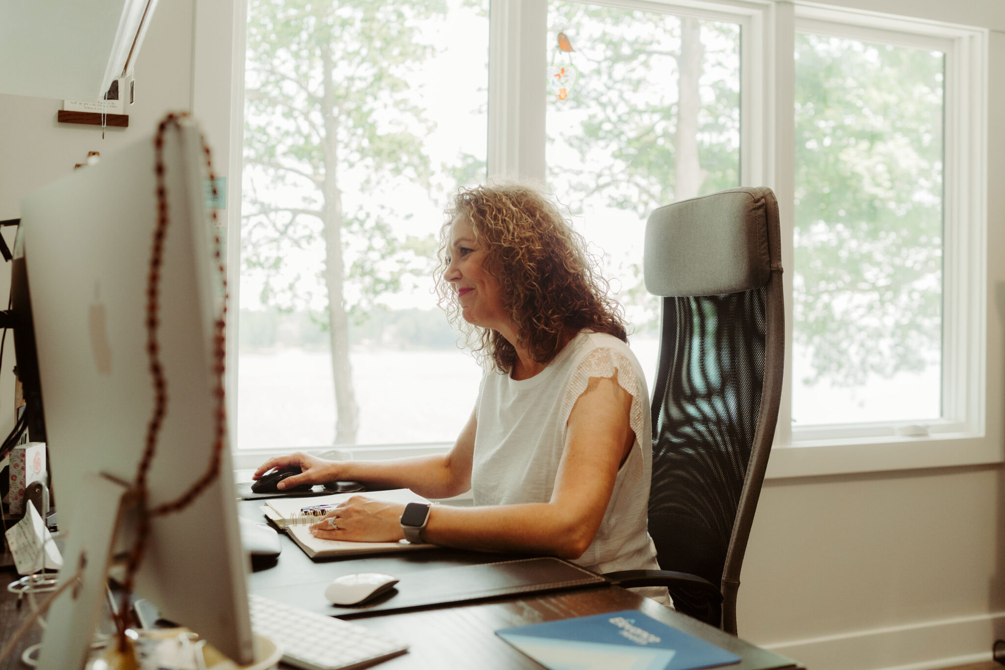Amy Collins, a Ball State Online MBA alum, sits at her desk, working on her computer.