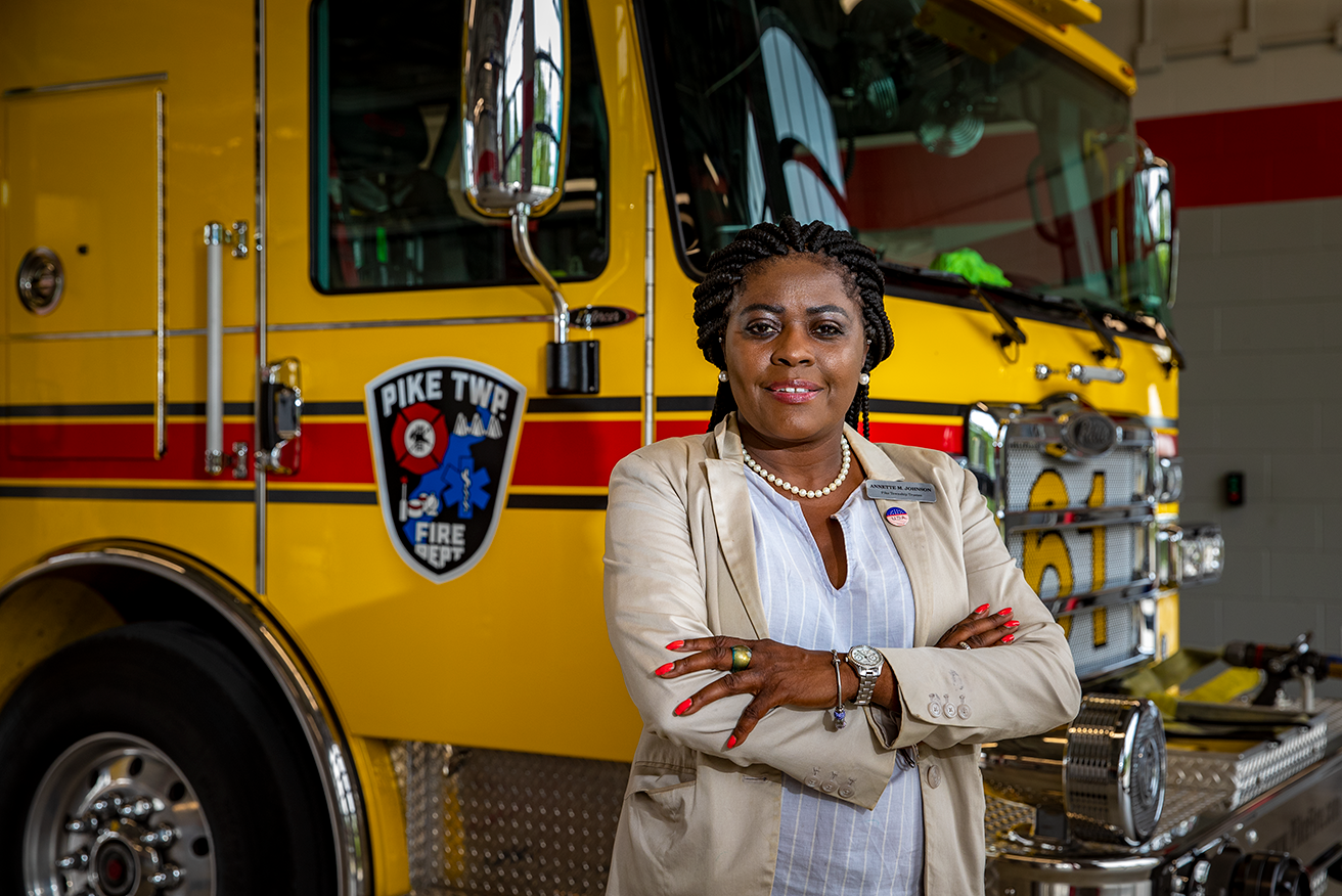 A women standing in front of a fire truck with arms crossed
