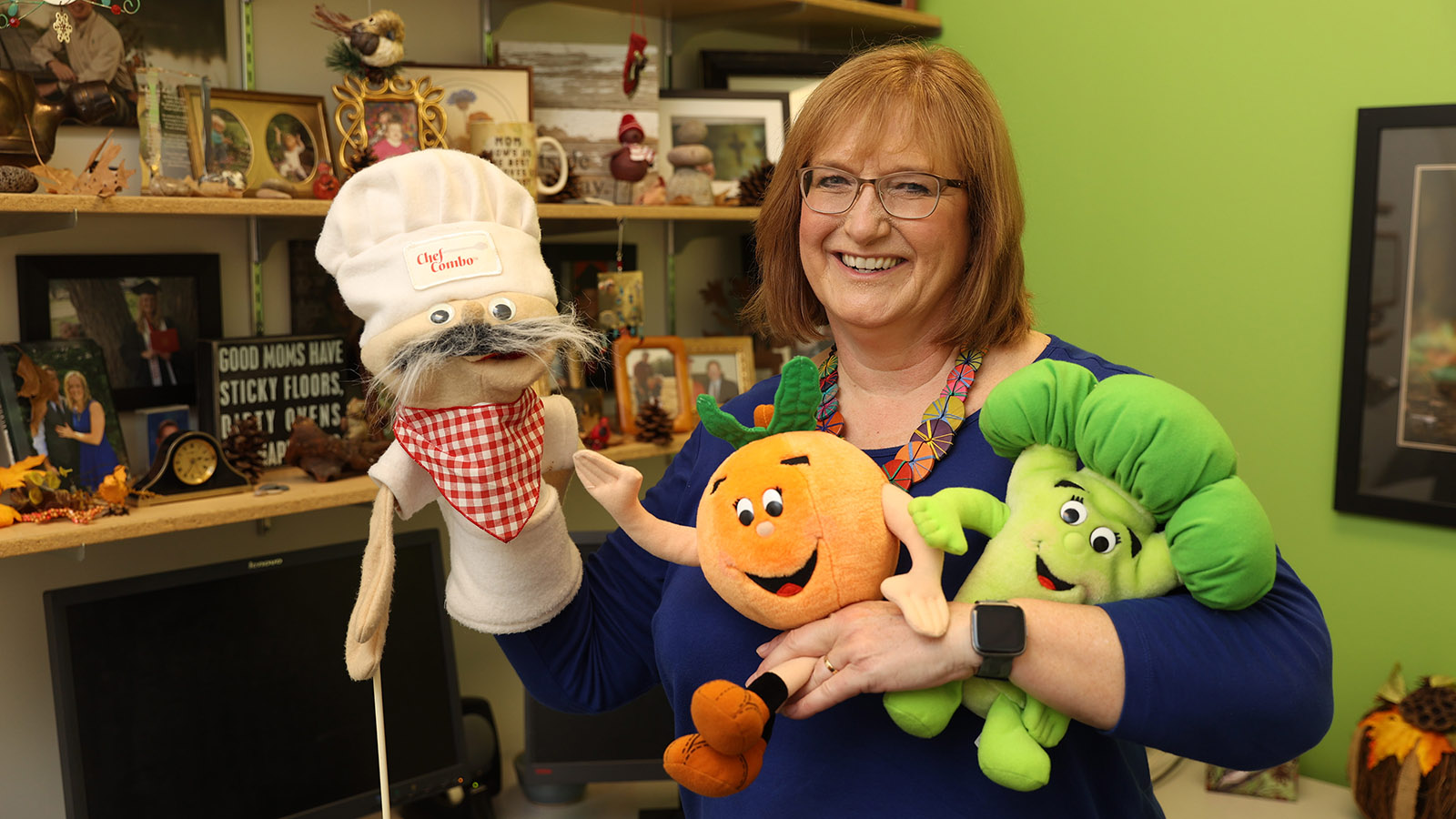 Carol Friesen holding puppets that she uses to educate children about nutrition