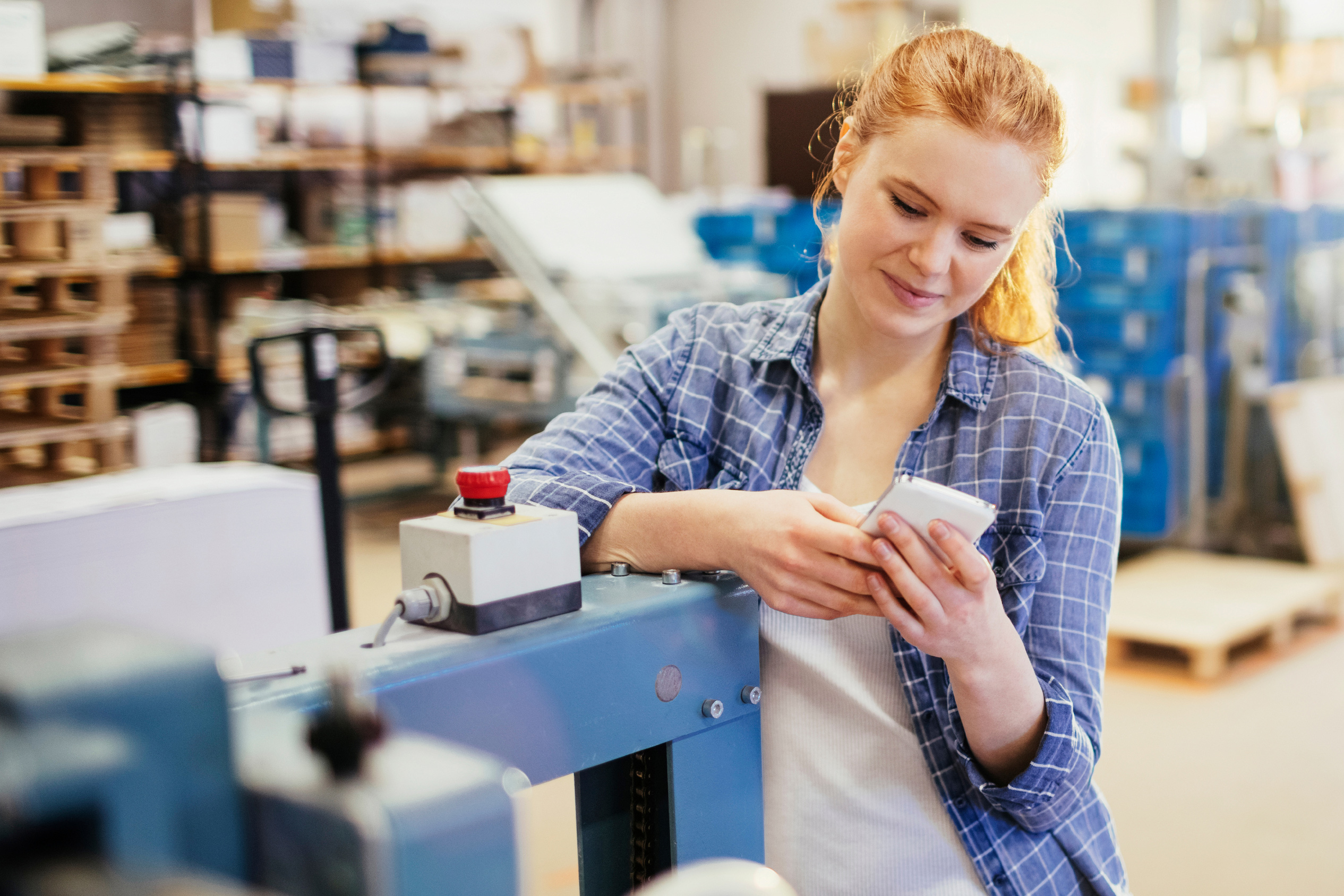 Online bachelor's student working as an intern in a supply warehouse checking a tablet